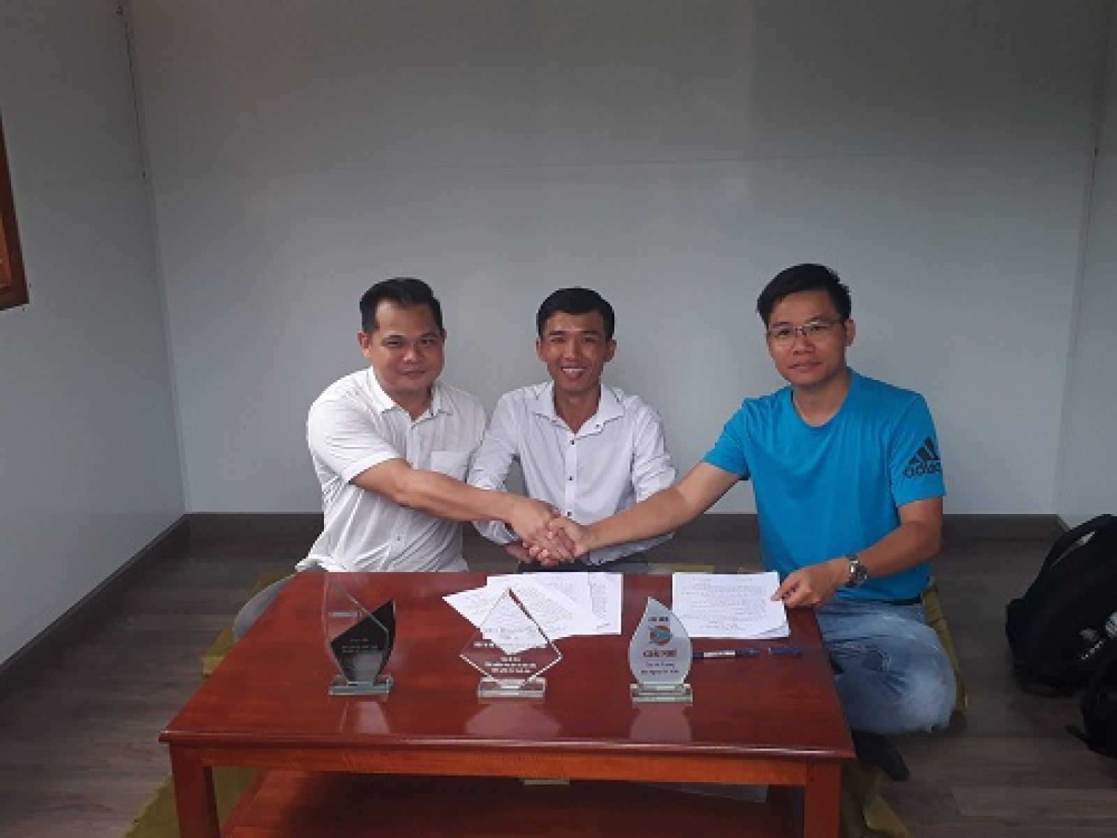 Trong gian phòng khách của nhà nổi, Nguyễn Minh Hoàng (giữa) và 2 doanh nhân ký kết hợp đồng đầu tư. Ảnh: Hà Thế An.